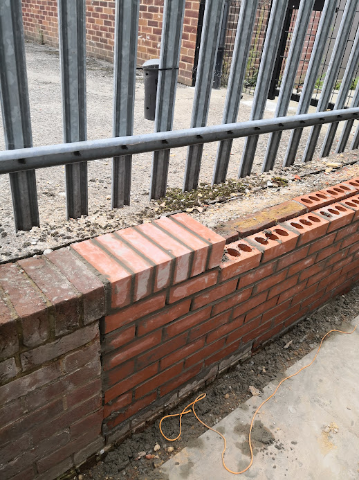 Repaired brick boundary wall with new facing bricks and professional brickwork restoration in Hertfordshire.