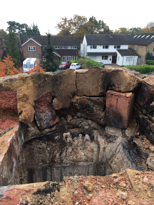 Damaged chimney stack before refurbishment showing severe deterioration and failed brickwork.