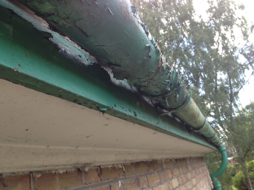 Close-up of deteriorated guttering with peeling paint and corrosion before gutter refurbishment in Hertfordshire.