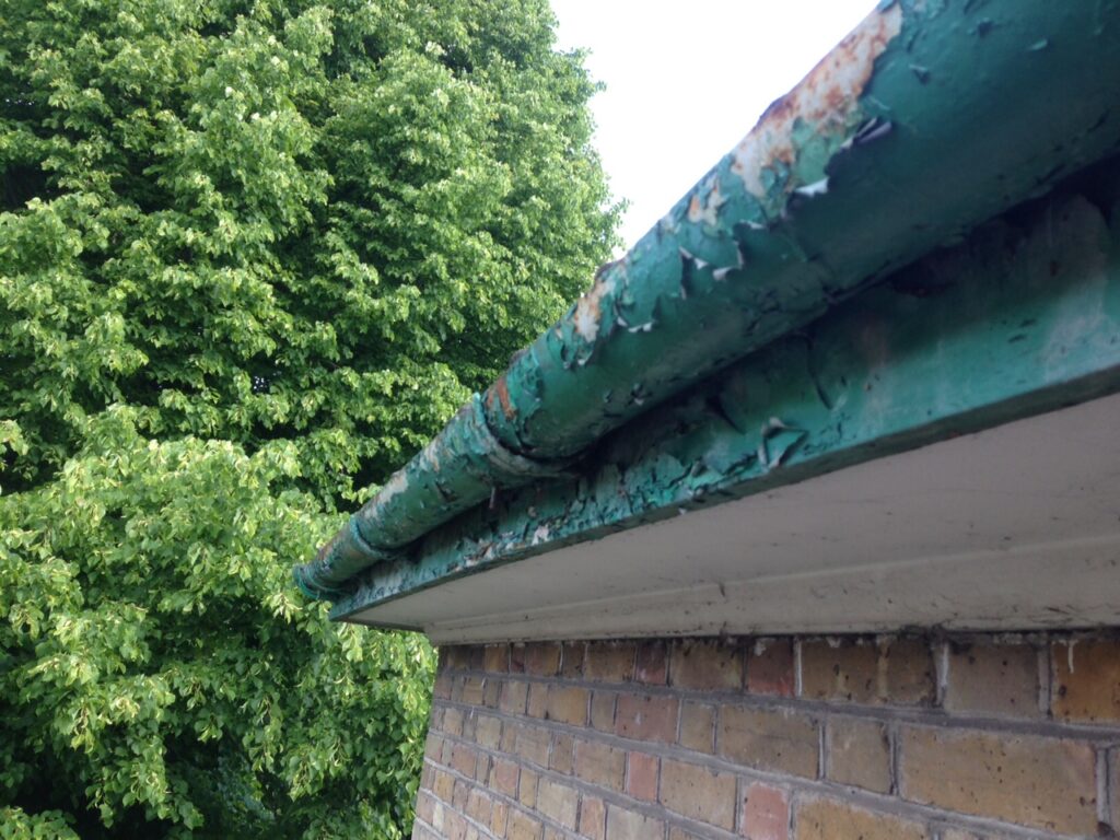 Before gutter refurbishment showing peeling paint, corrosion and worn guttering on a property in Hertfordshire.