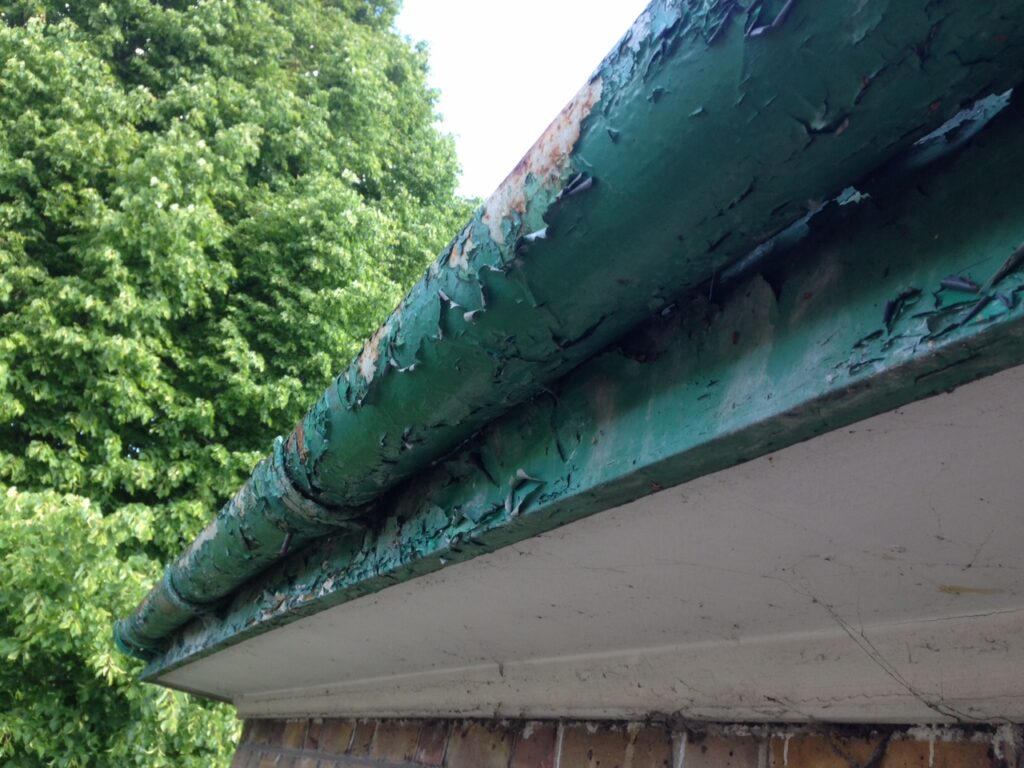 Old painted gutter with peeling paint and visible deterioration before professional gutter refurbishment in Hertfordshire.