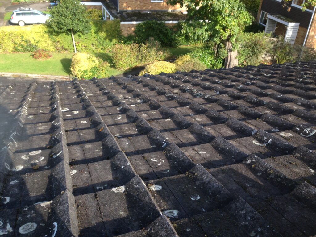 Weathered concrete roof tiles with moss and lichen before professional roof cleaning by RidgeOak in Hertfordshire.