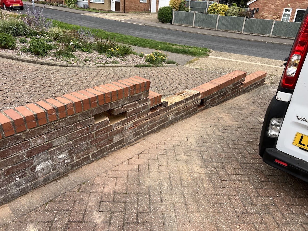 Brick driveway boundary wall before partial rebuilding in Hertfordshire